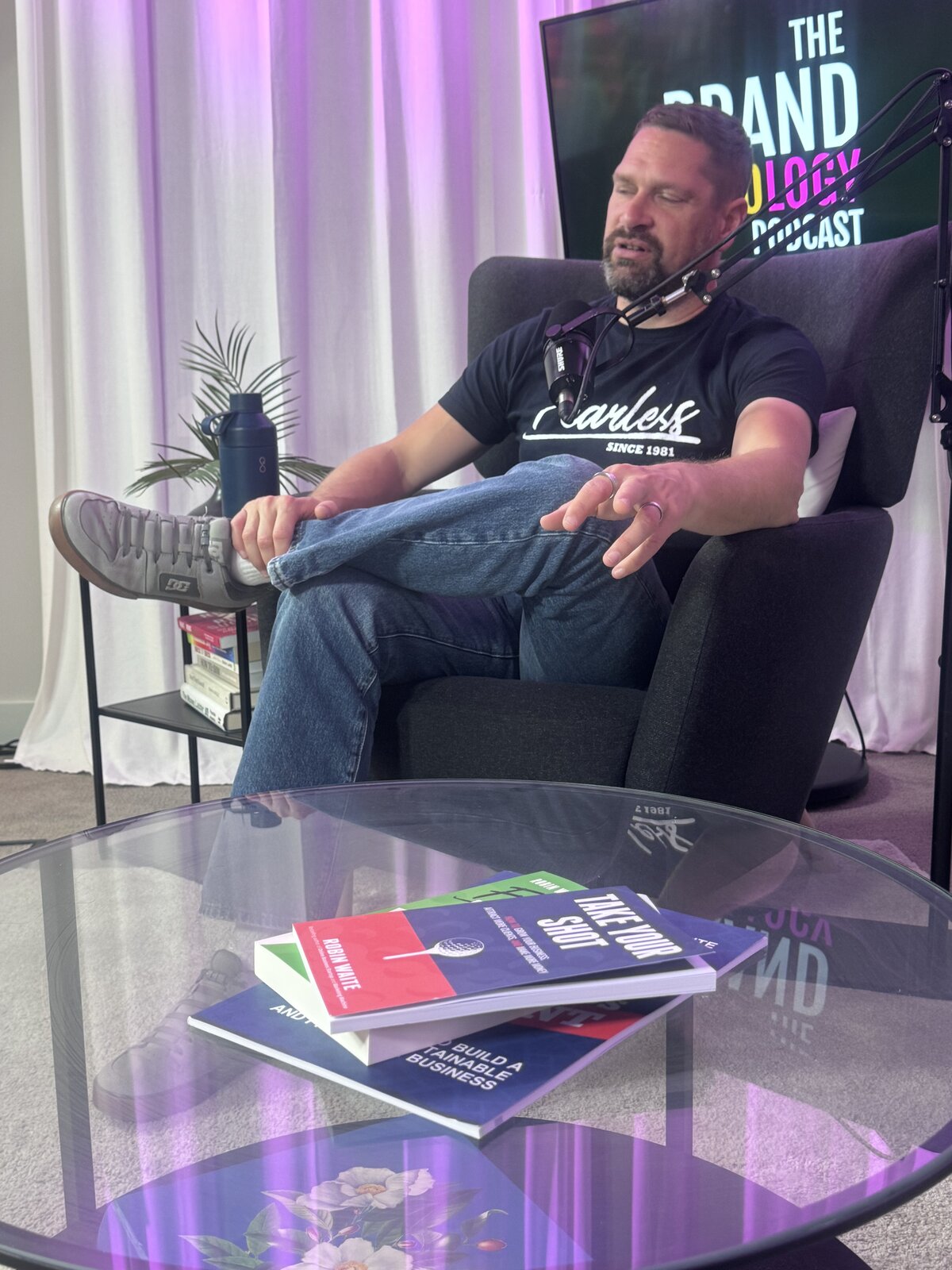 Robin Waite mid-conversation in the studio, with his books on the table